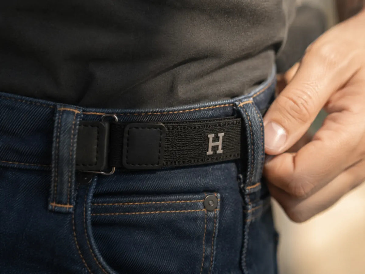 Una pieza negra de HILVÁN ya instalada uniendo dos trabillas de un pantalón de mezclilla